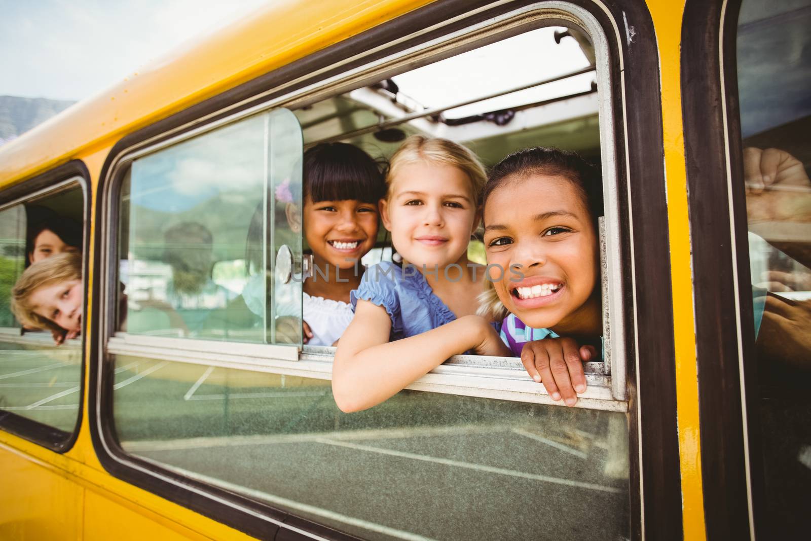 Cute pupils smiling at camera in the school bus by Wavebreakmedia