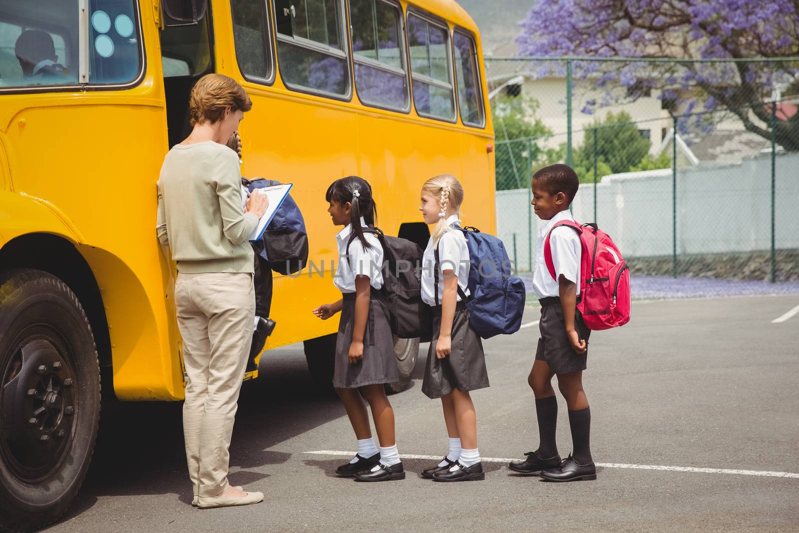 Cute schoolchildren waiting to get on school bus by Wavebreakmedia