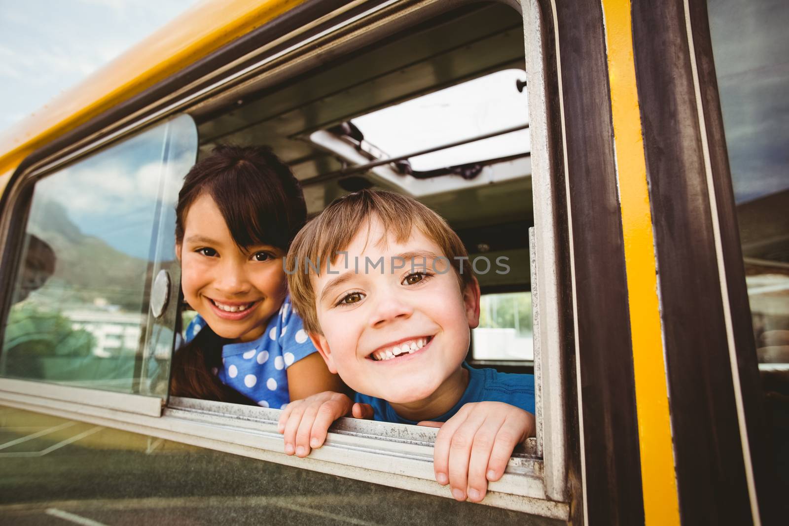 Cute pupils smiling at camera in the school bus by Wavebreakmedia