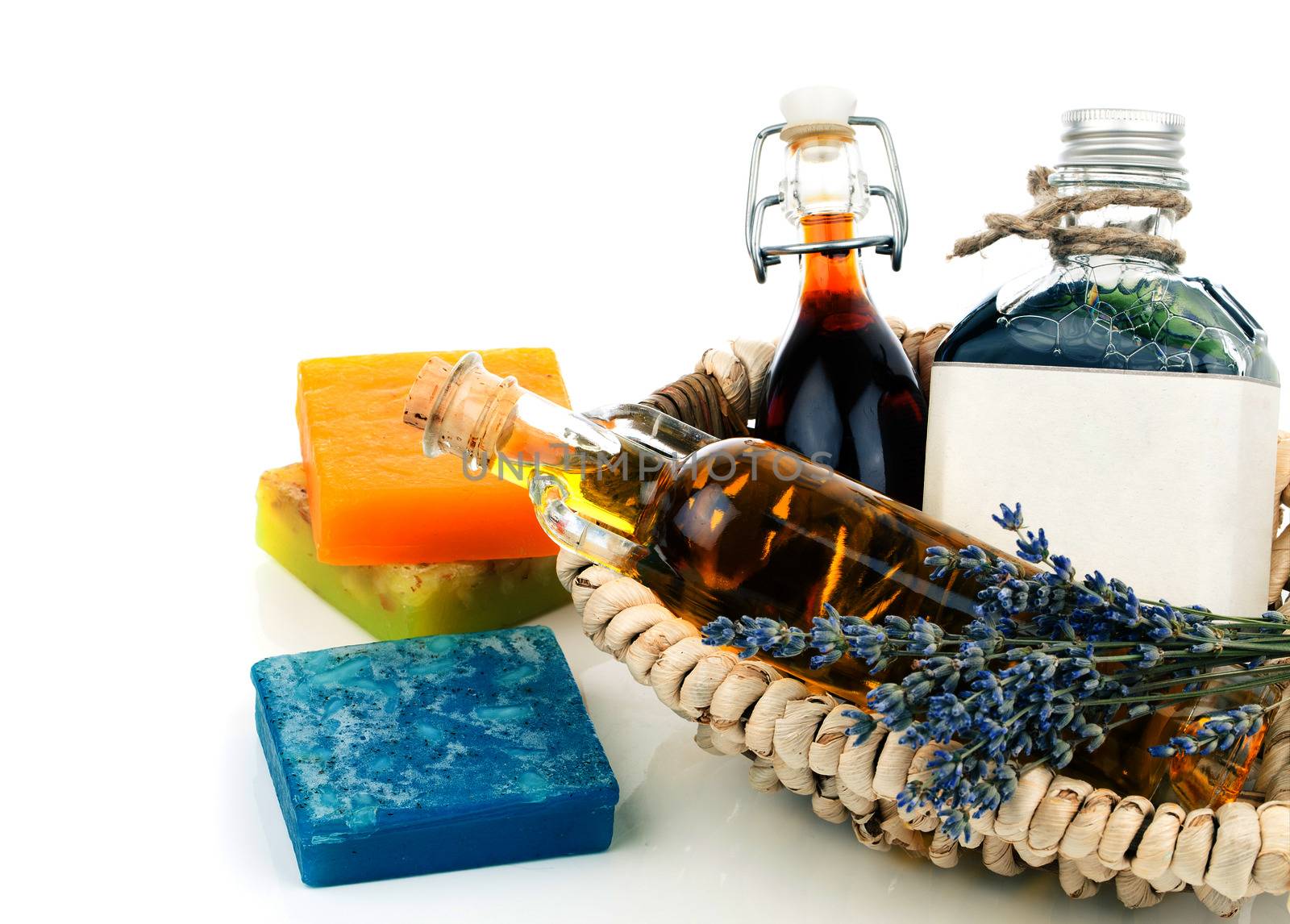 Essential various oils with soap and lavender flowers, on white background.