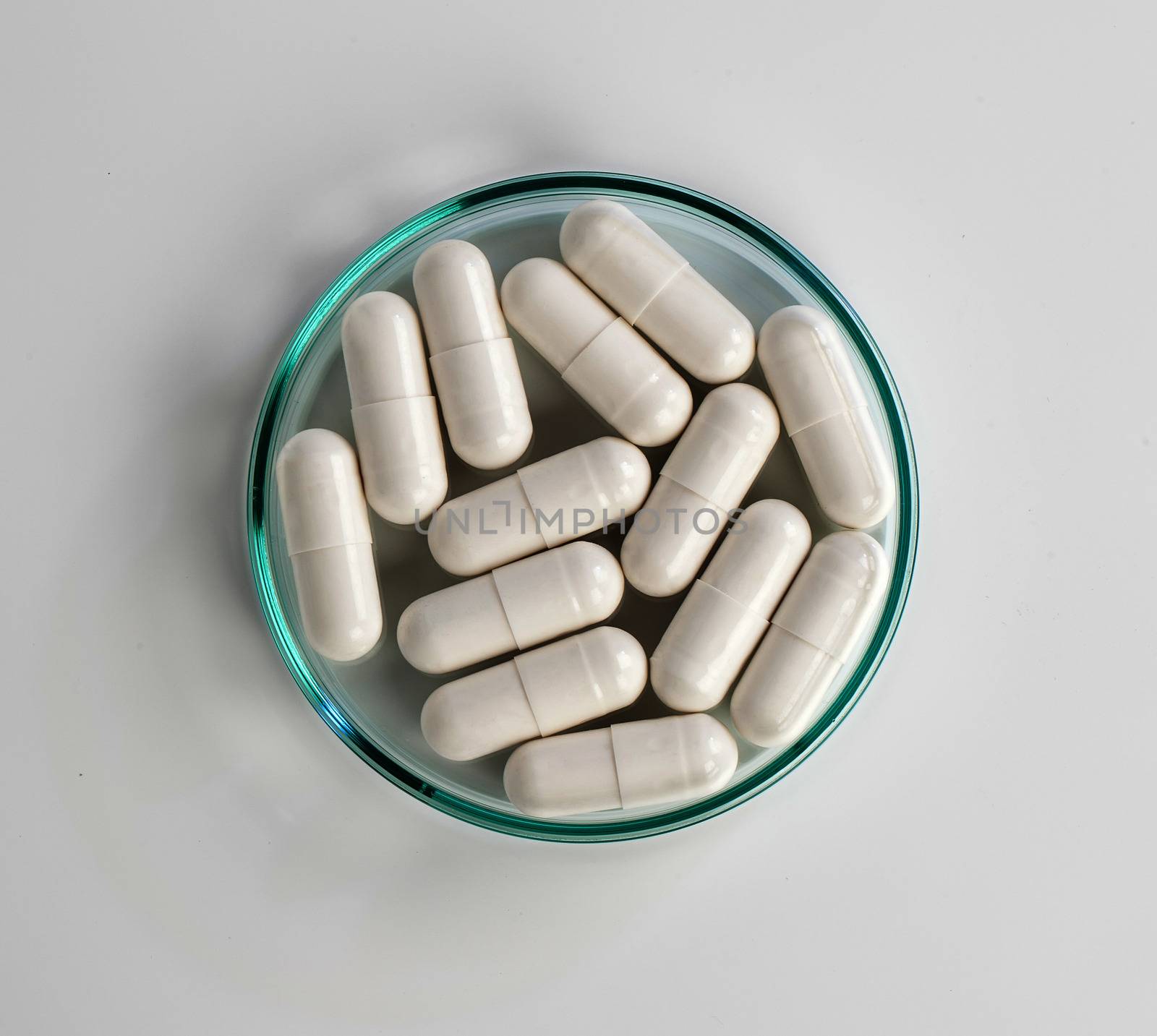 Close up of white medical capsules on white background by motorolka