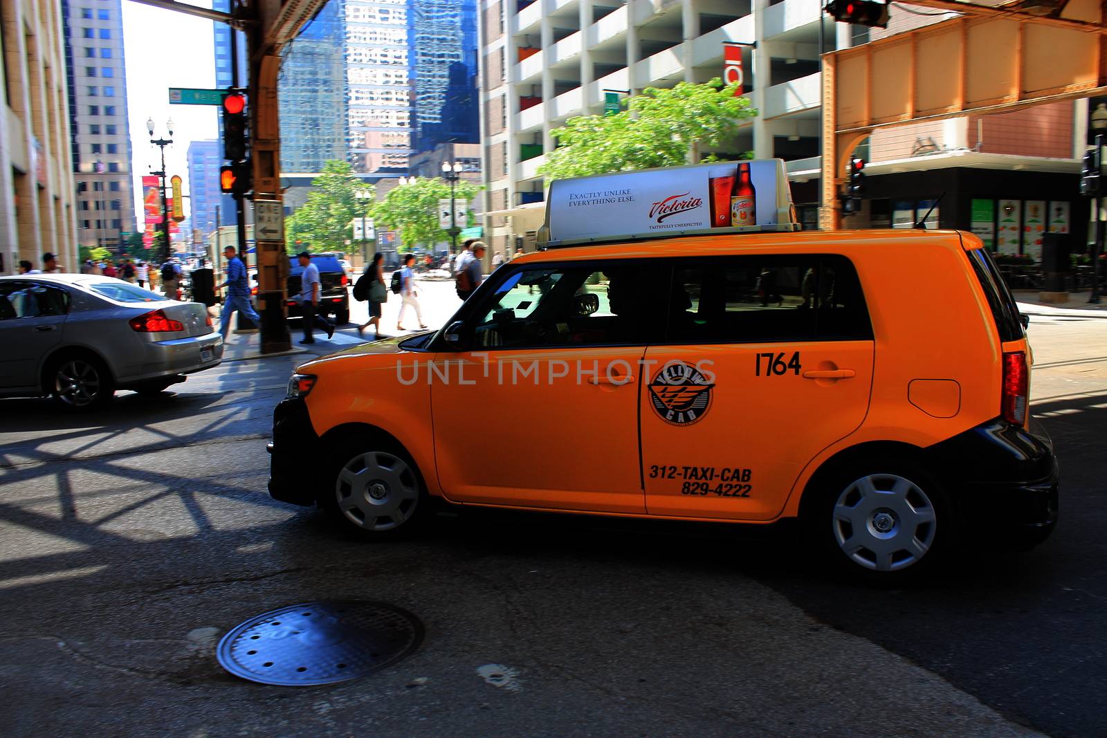 A turning yellow taxicab in downtown Chicago.