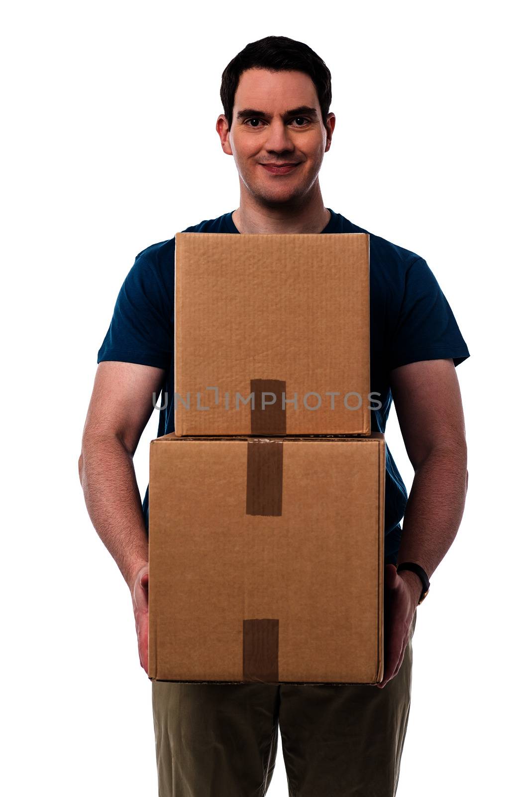 Smiling casual guy holding pile of boxes