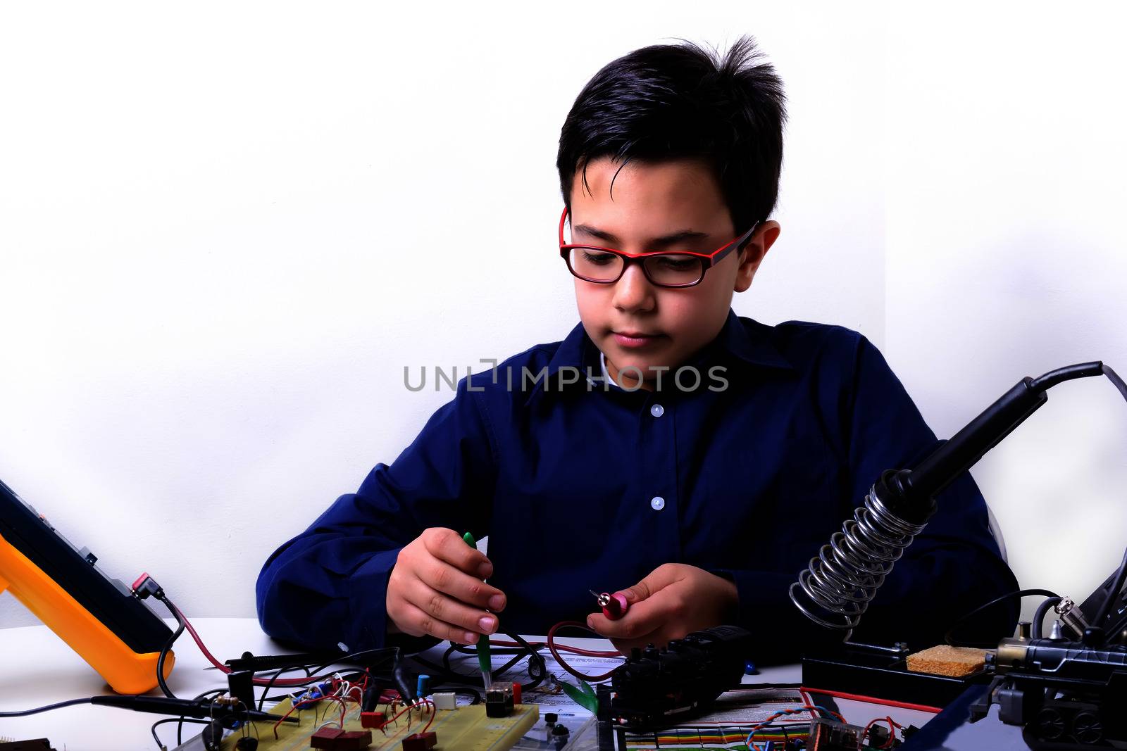 Young student performs experiments in electronics and dreams of the future.