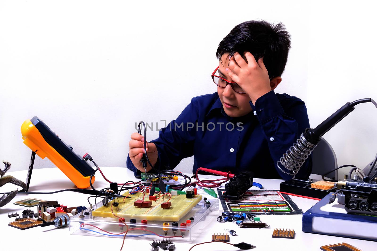 Young student performs experiments in electronics and dreams of the future.