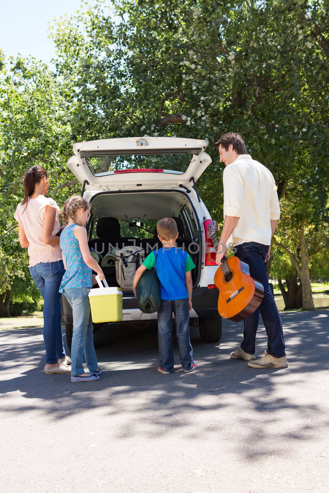 Happy family getting ready for road trip on a sunny day