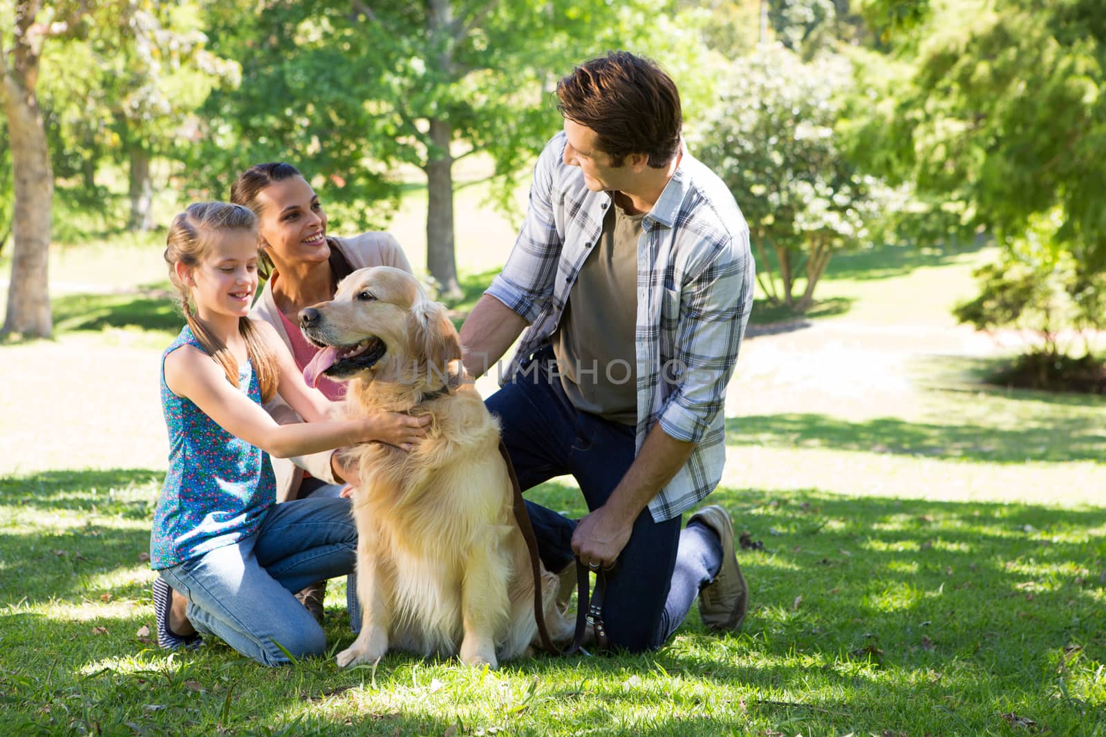 Happy family with their dog in the park on a sunny day