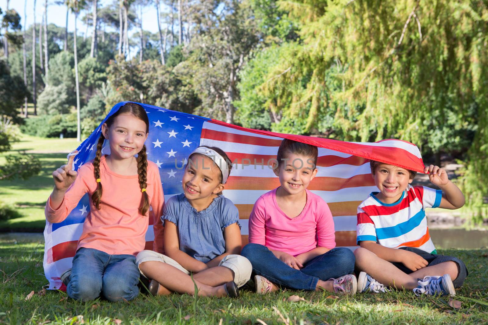 Happy little friends with american flag by Wavebreakmedia