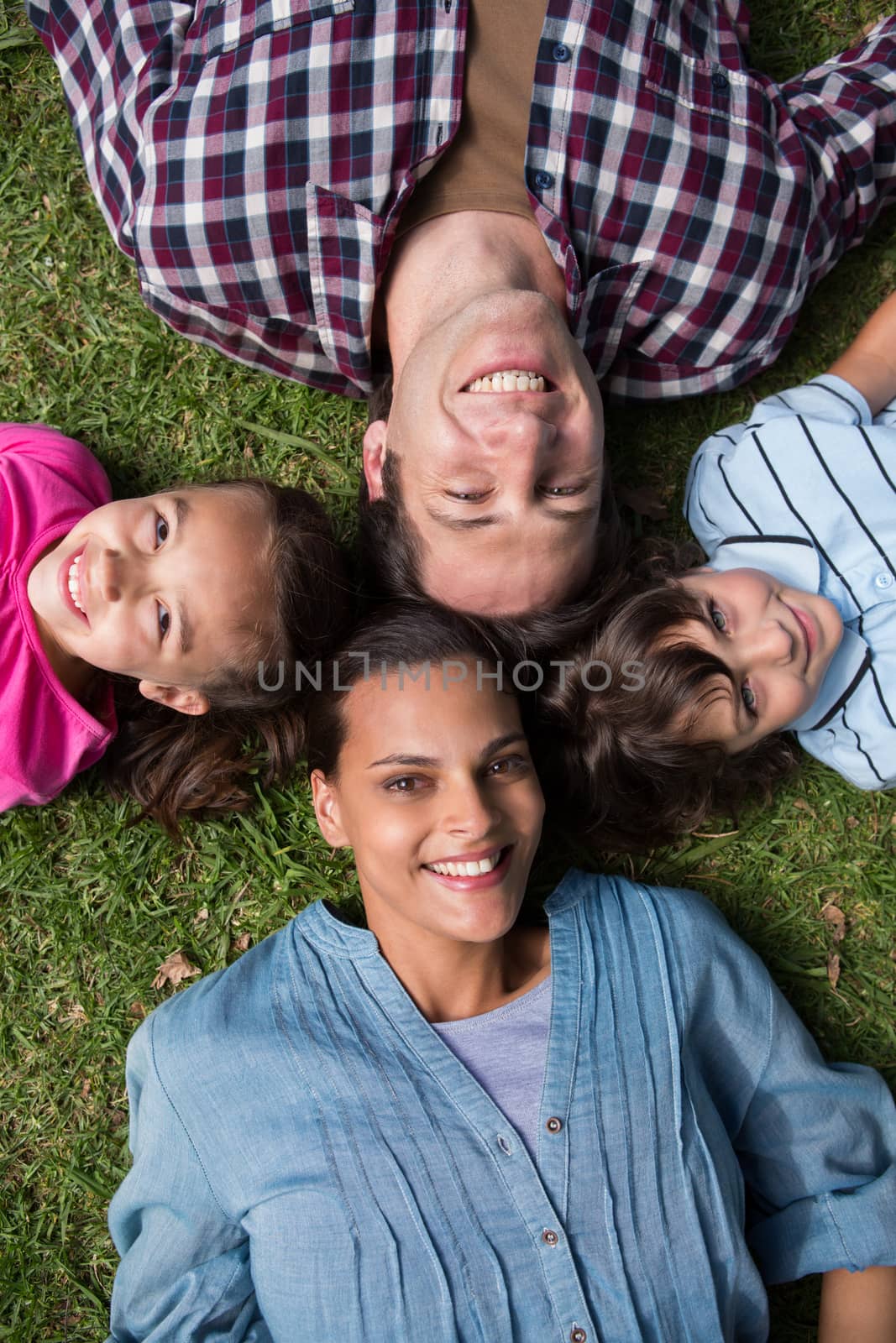 Happy family smiling at camera on a sunny day