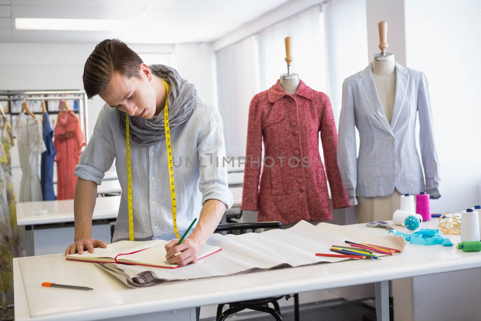 Fashion student taking notes on notebook by Wavebreakmedia