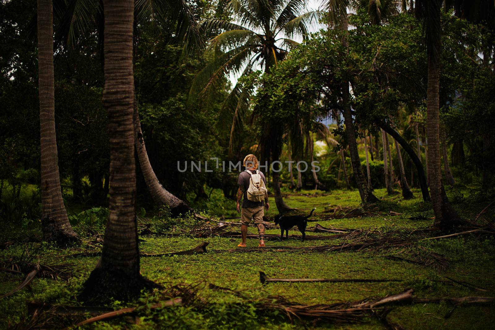 Man with a dog in tropical thailand garden