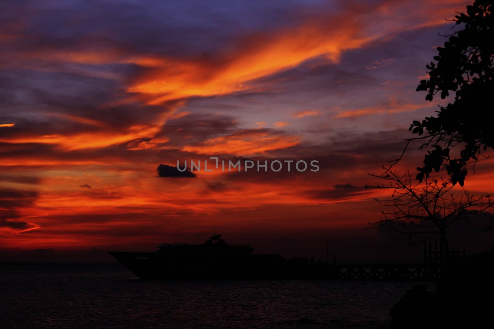 Sunset on island with boat on horizon