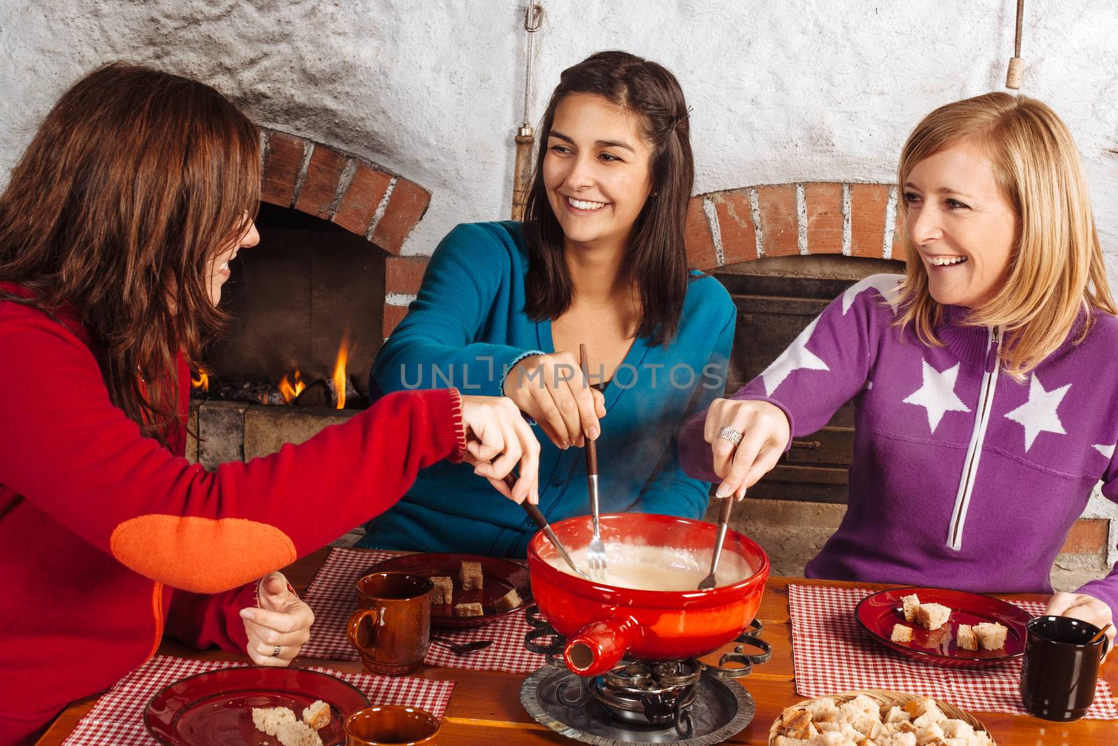 Friends having fondue dinner by sumners