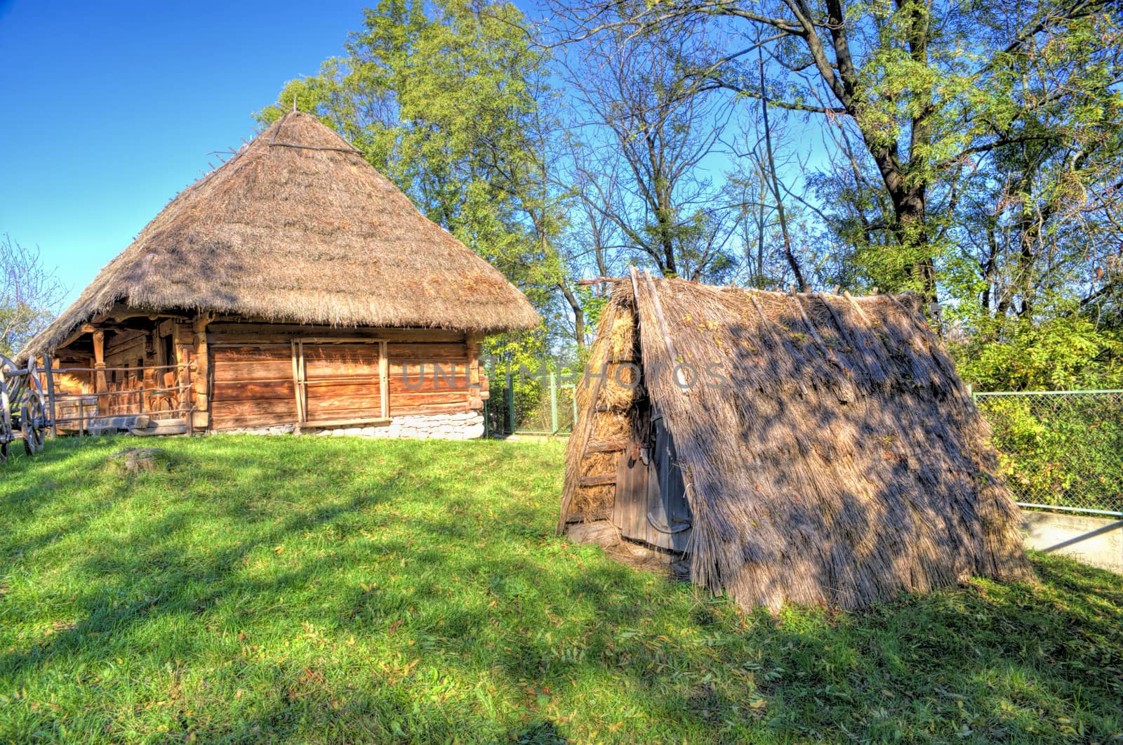 Thatched cellar for agricultural products in the farmhouse courtyard of a wooden house