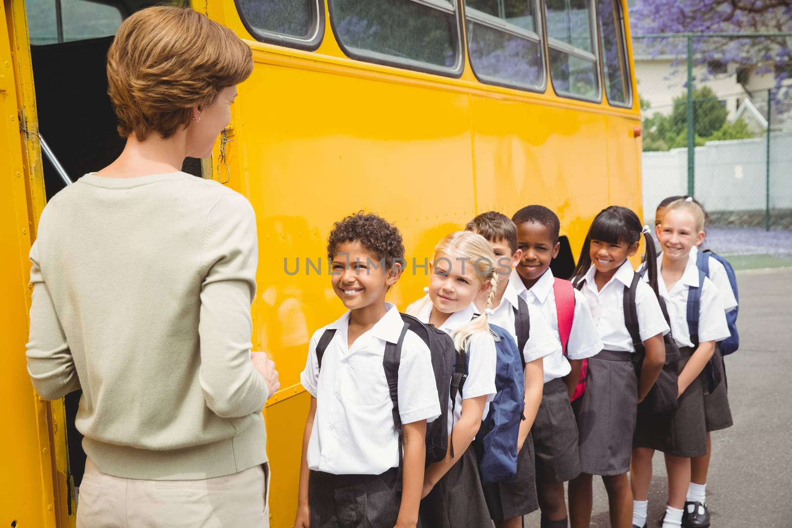Cute schoolchildren waiting to get on school bus by Wavebreakmedia