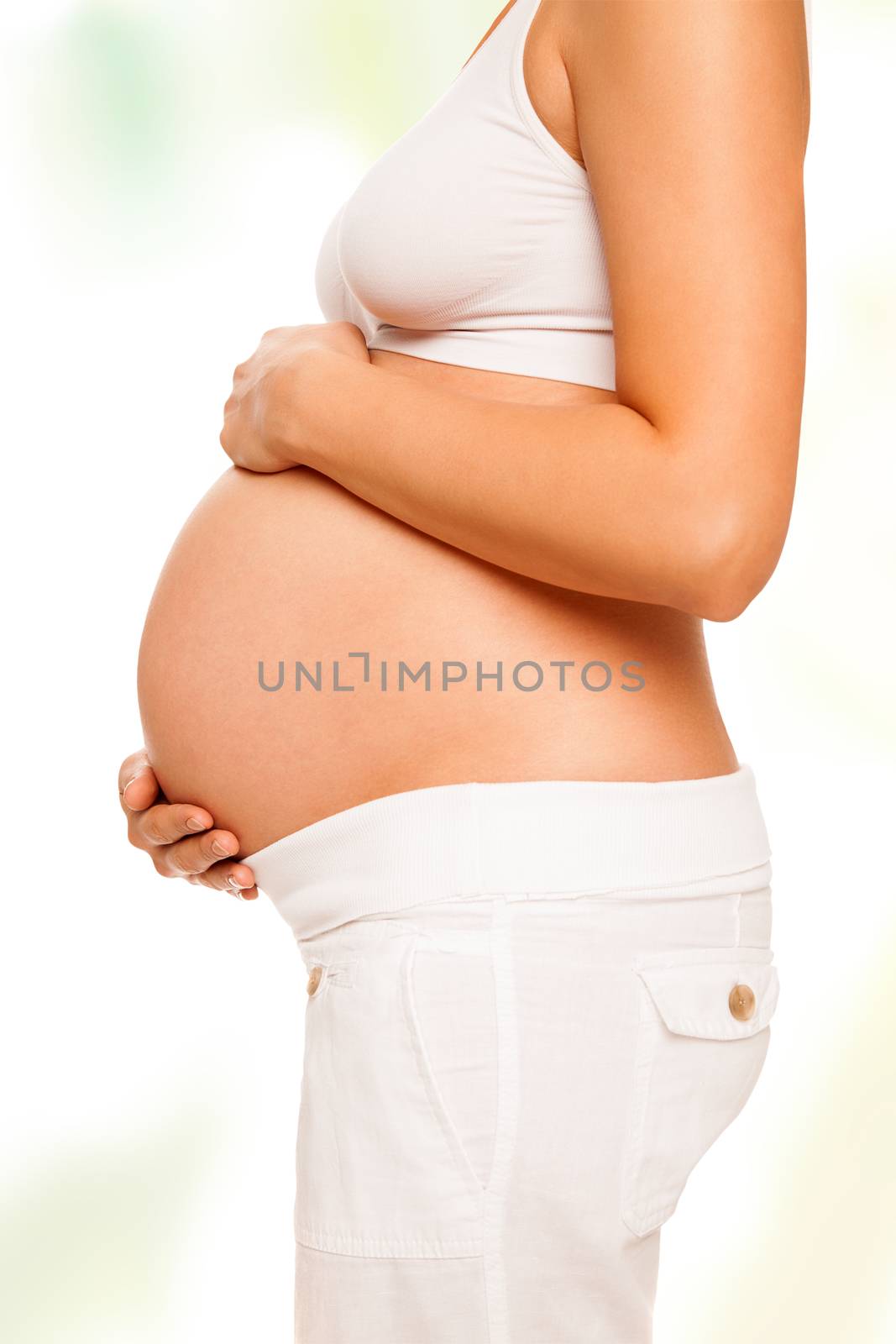 Pregnant woman is holding her abdomen on light background, isolated with work path.