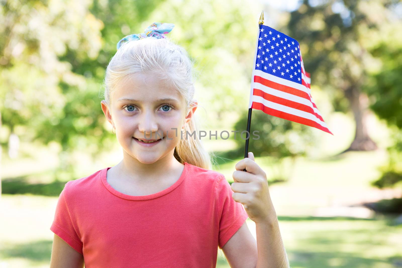 Little girl waving american flag by Wavebreakmedia