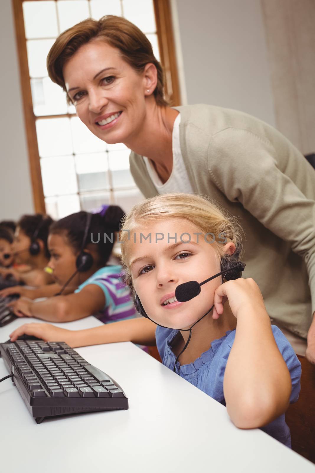 Cute pupils in computer class with teacher at the elementary school