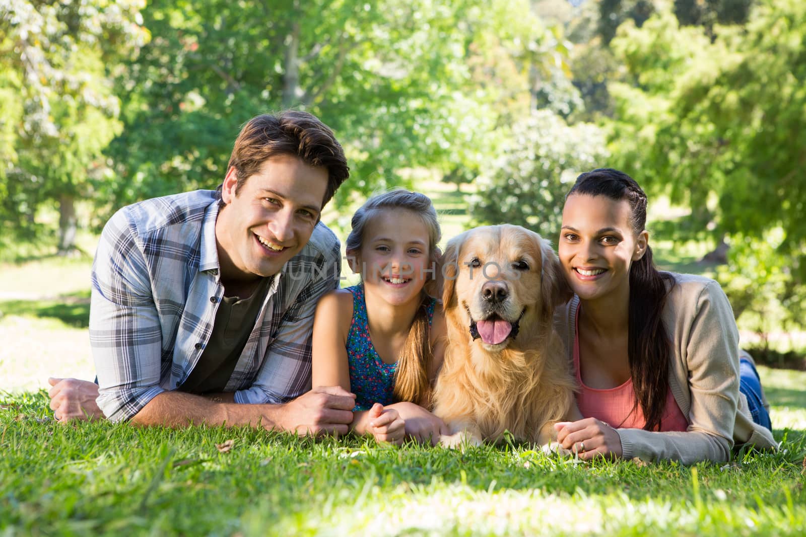 Happy family with their dog in the park on a sunny day