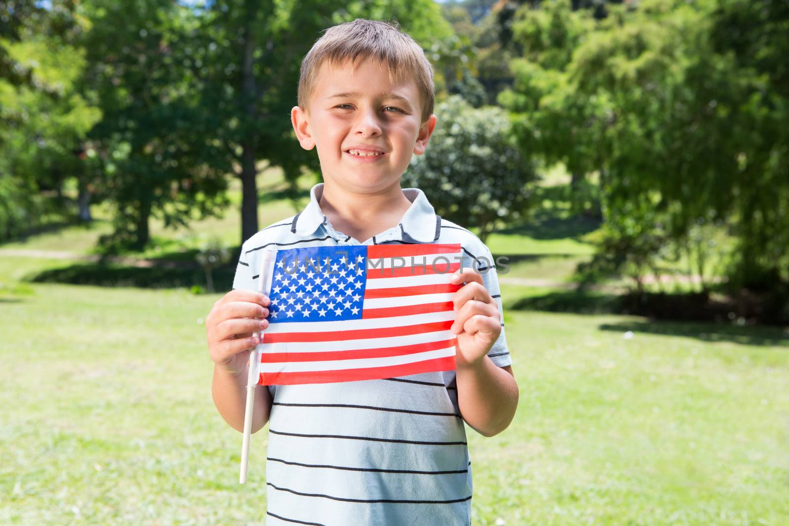 Little boy waving american flag on a sunny day