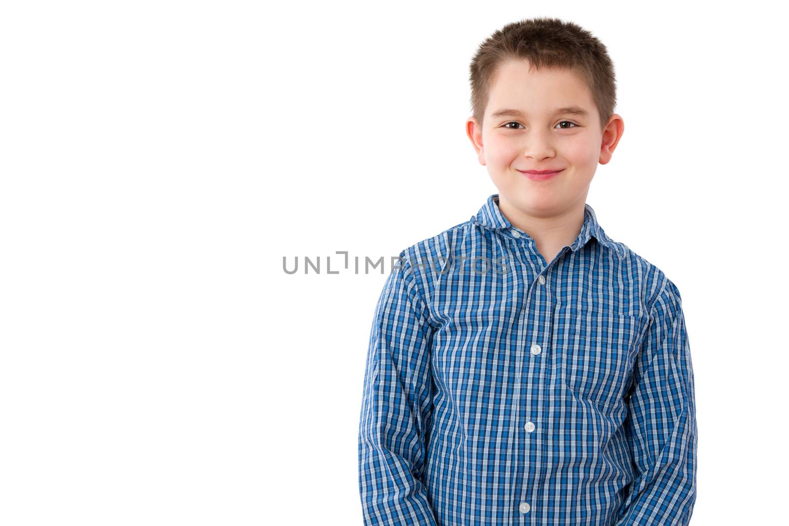 Portrait of a Cute 10 Year Old Boy with a Mischievous Sweet Smile, Standing Against White Background with Copy Space.