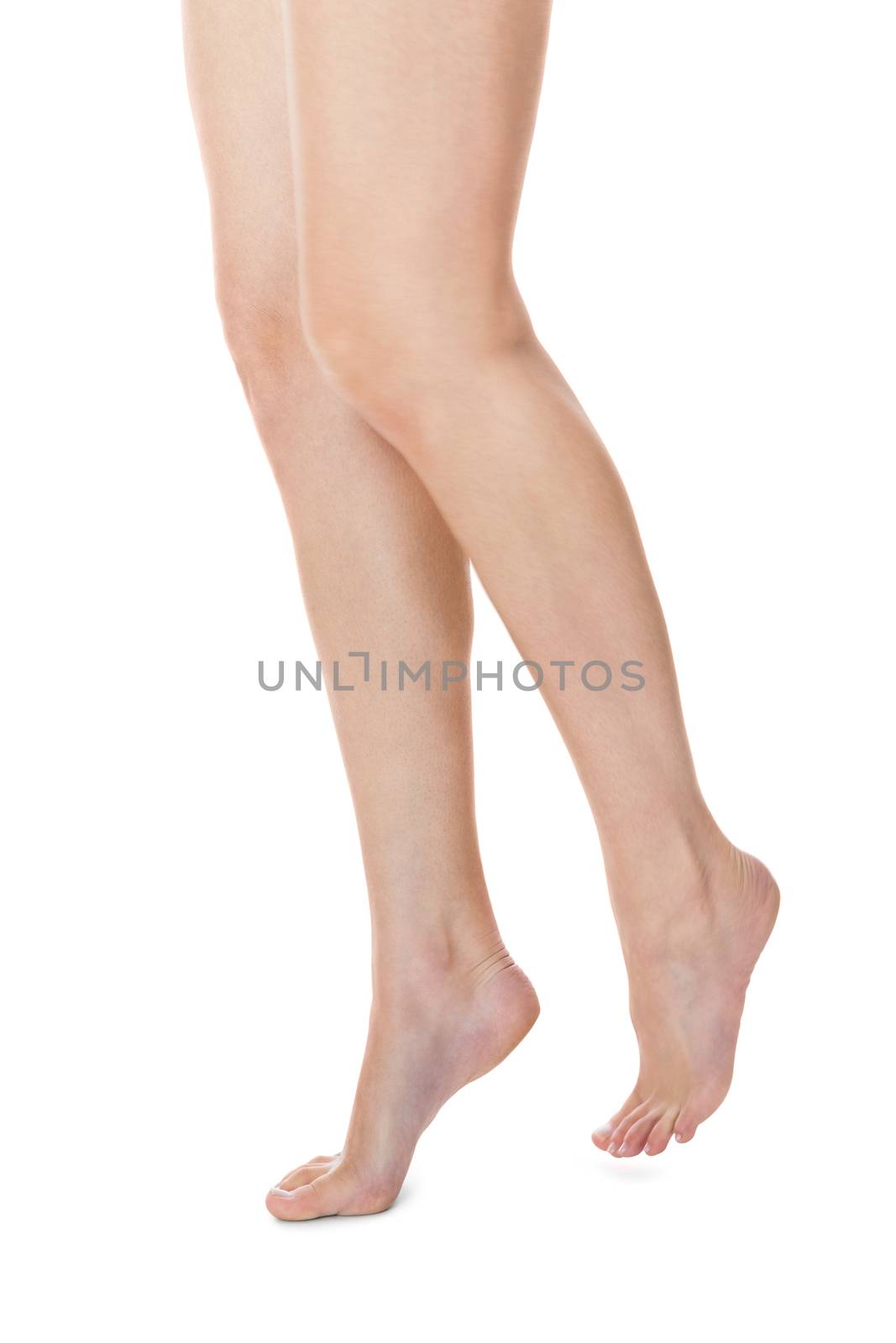 Elegant crossed long bare shapely female legs with bare feet viewed from above isolated on white with copyspace
