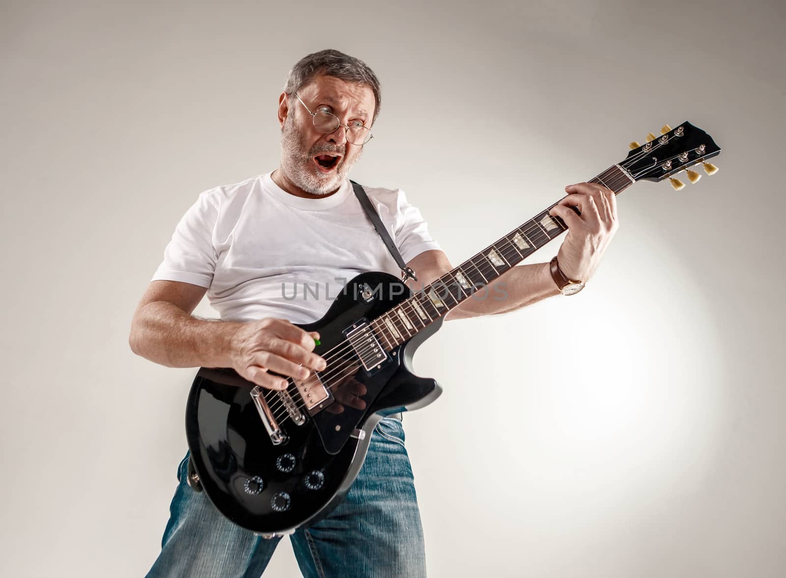 Portrait of a guitar player exciting music on gray background