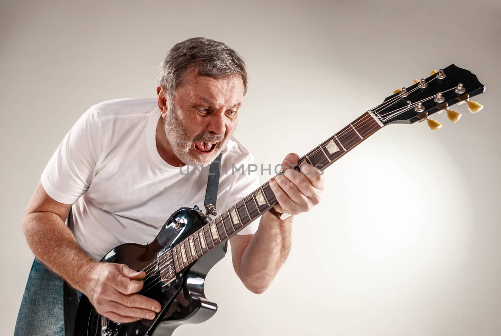 Portrait of a guitar player exciting music on gray background