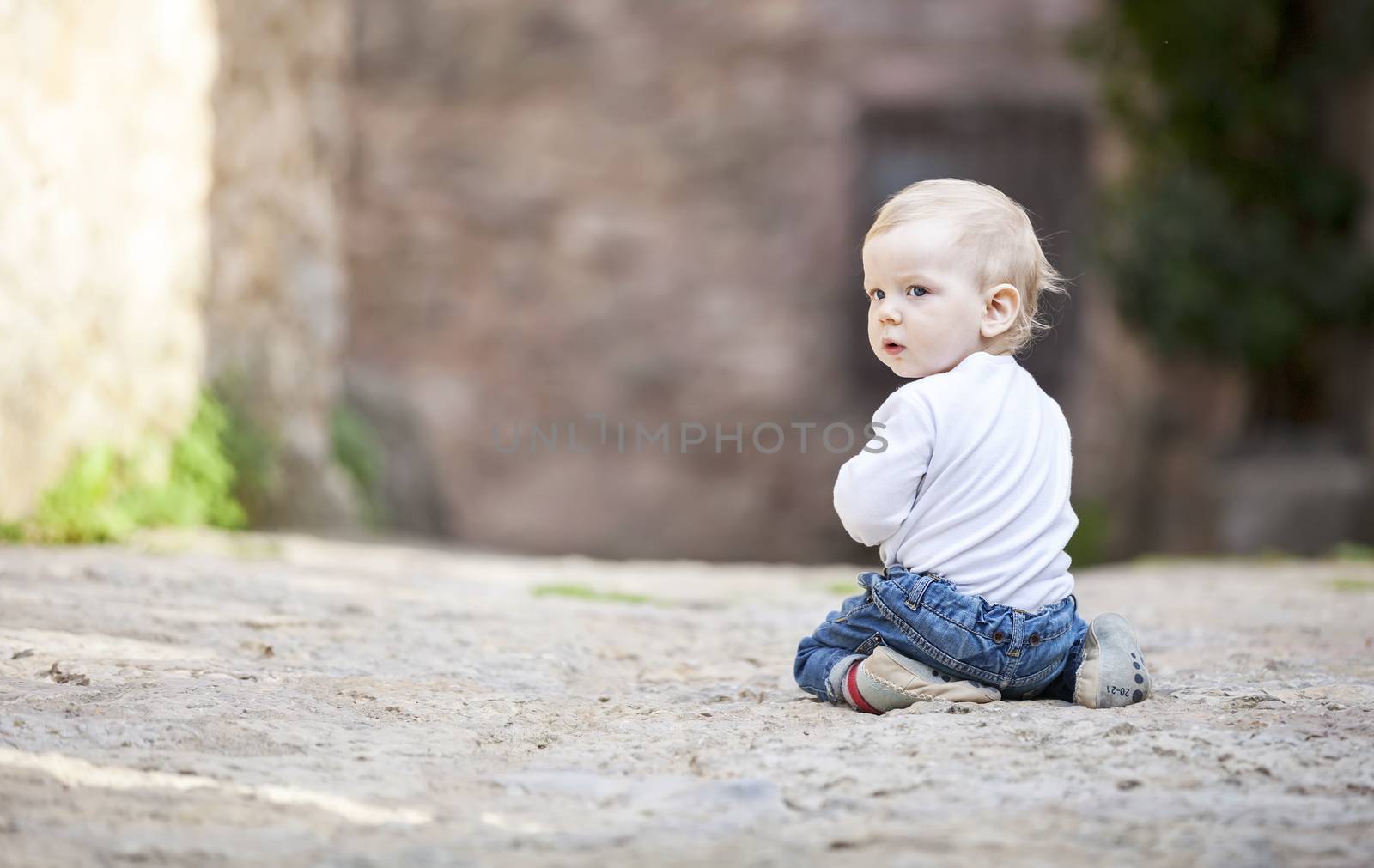 Little boy crawling on stone paved sidewalk by photobac