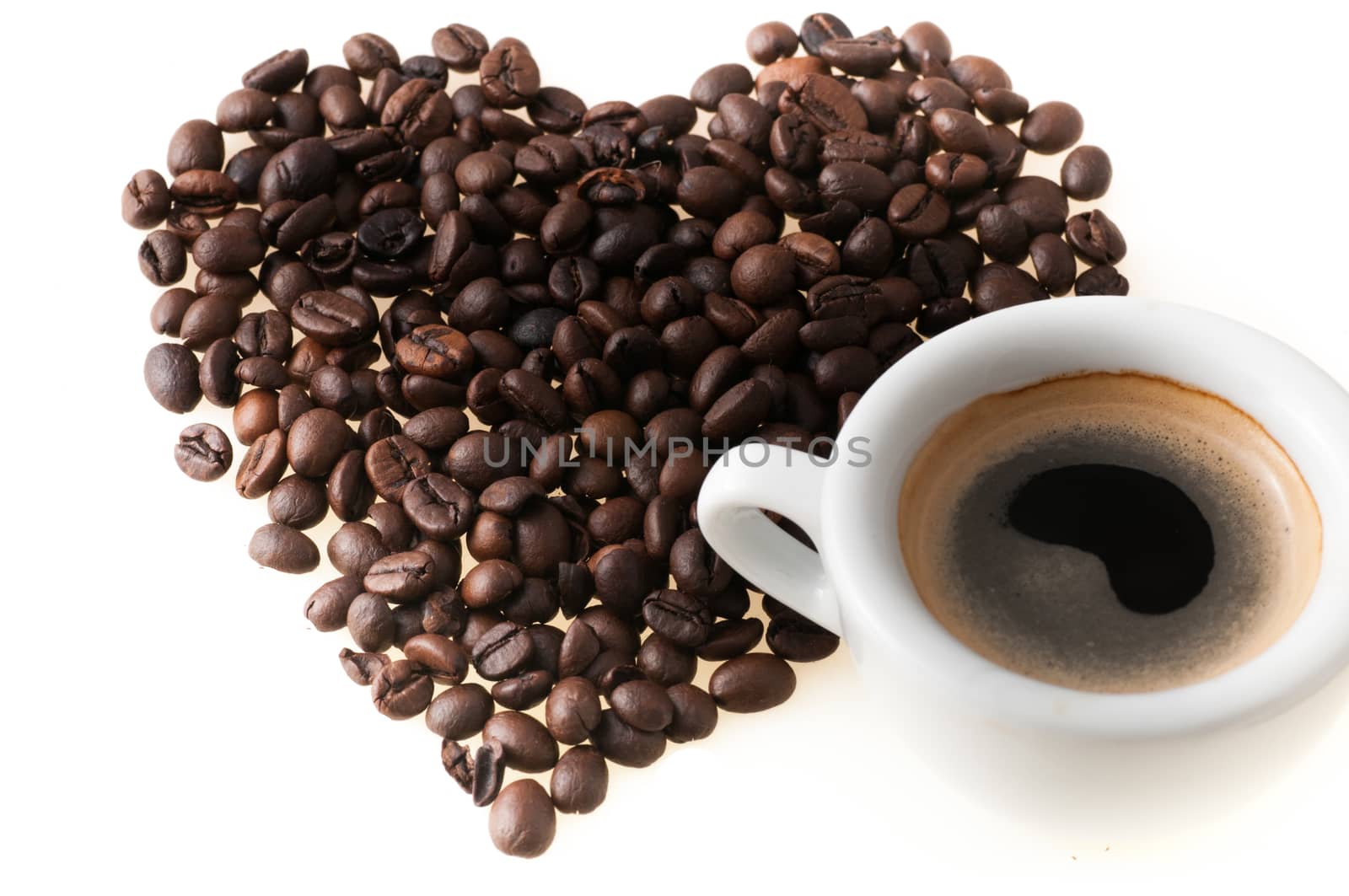 Heart shape made from coffee beans and cup of coffee