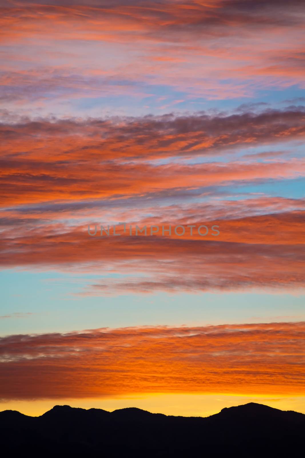 Colorful clouds in red and orange over mountain range