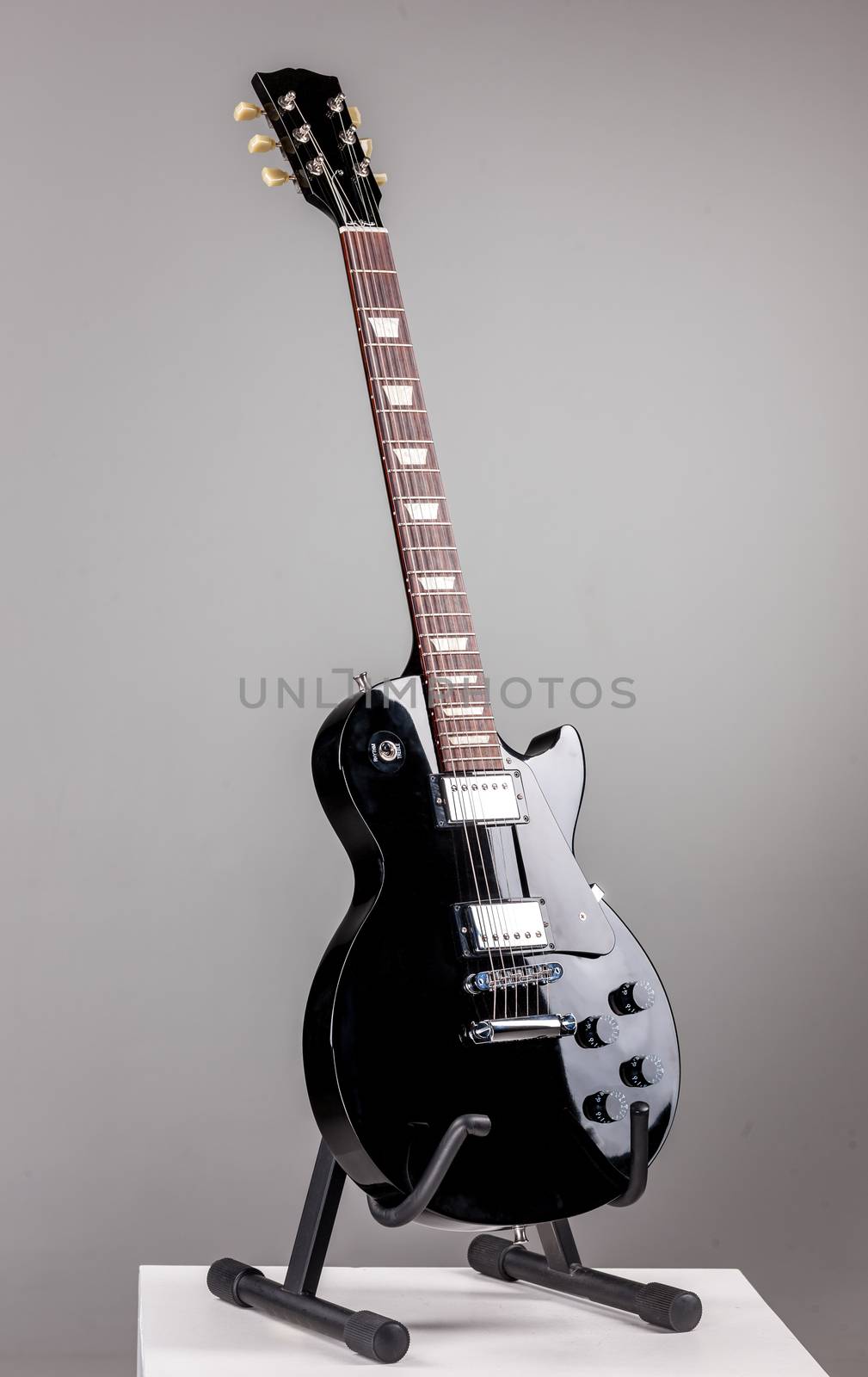 Electric guitar on a stand isolated over ghray background