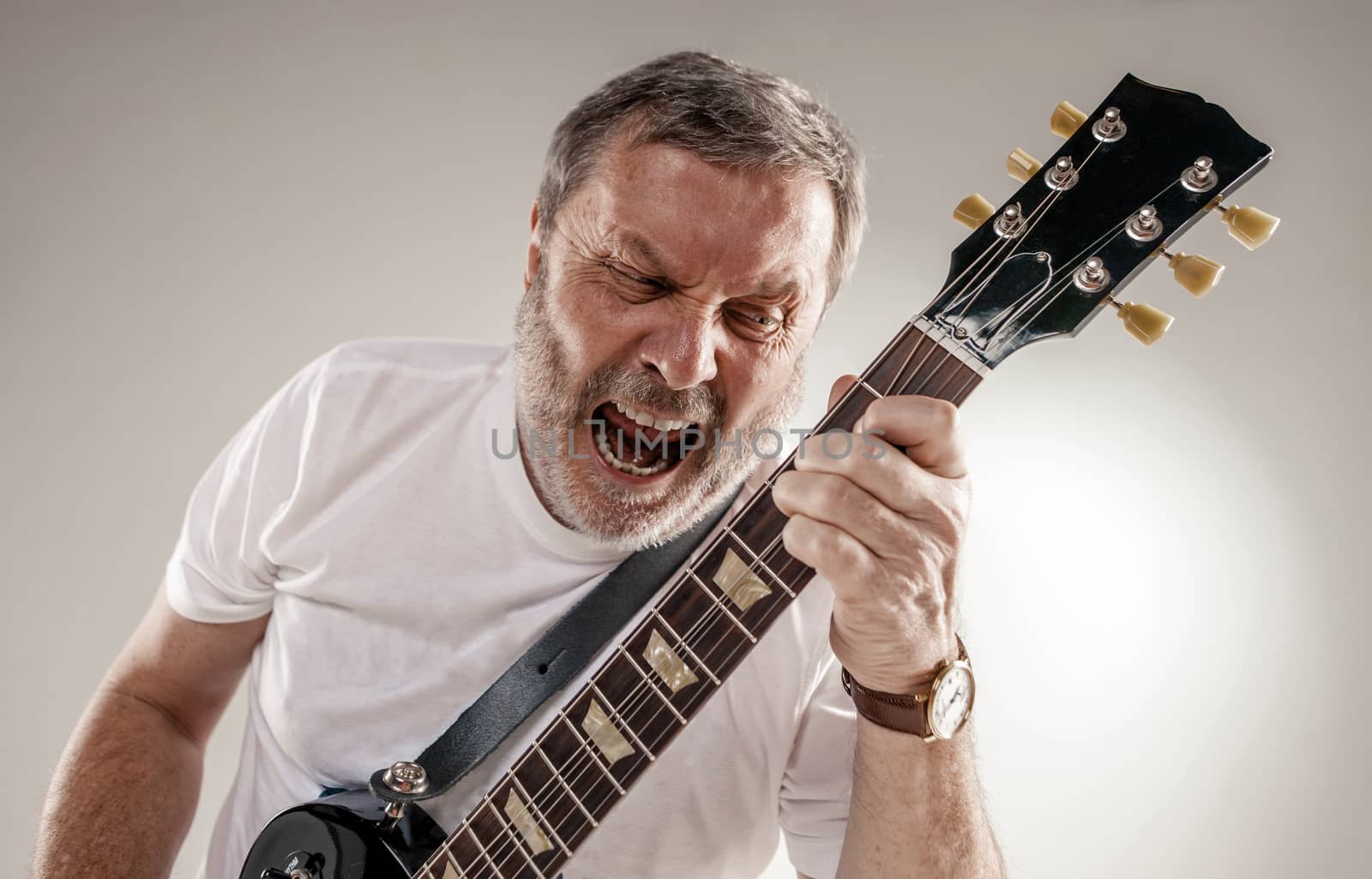 Portrait of a guitar player exciting music on gray background