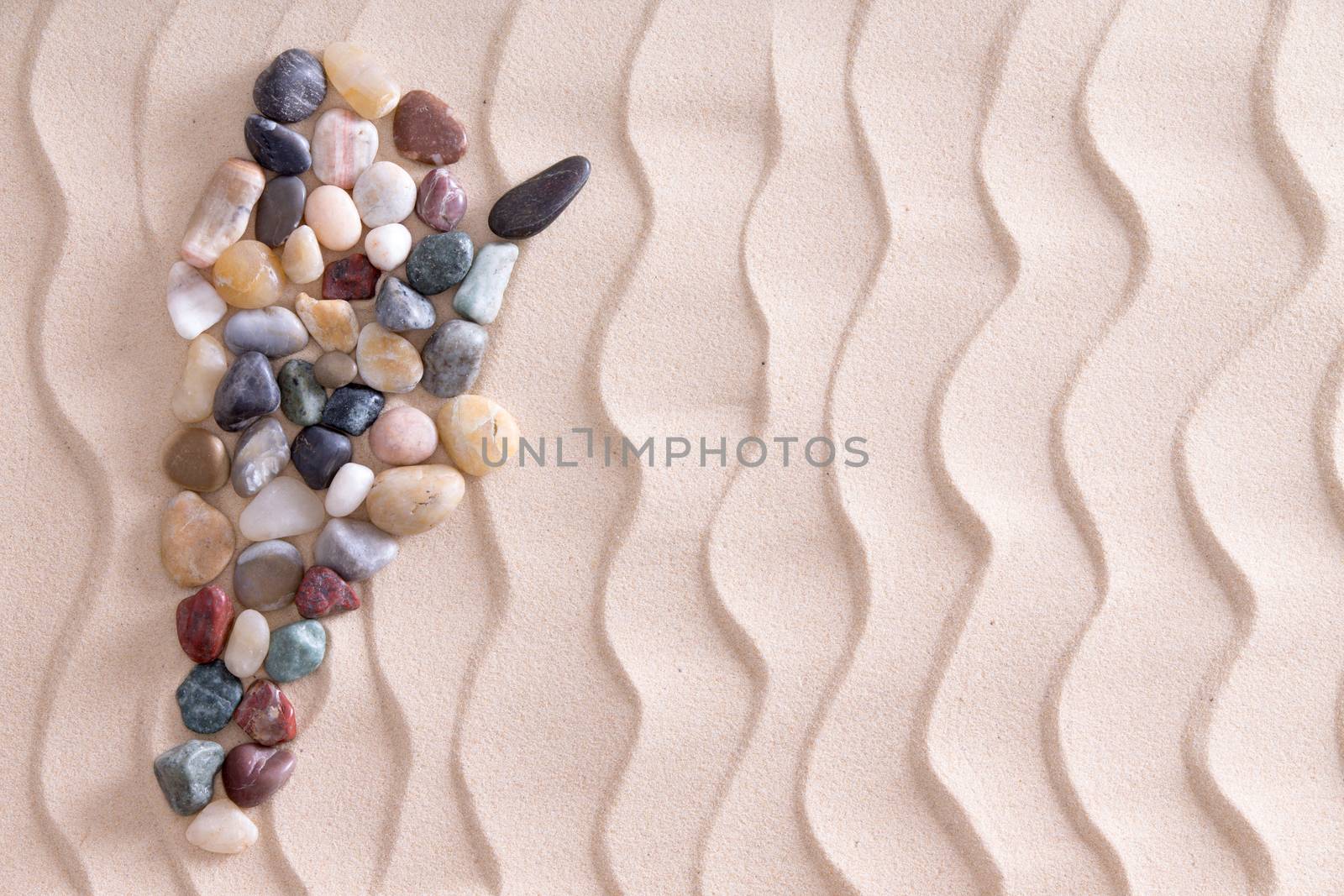 Creative colorful pebble map of Argentina using smooth waterworn agate and quartzite stones on decorative beach sand with a wavy pattern depicting ripples, with copyspace for a travel template