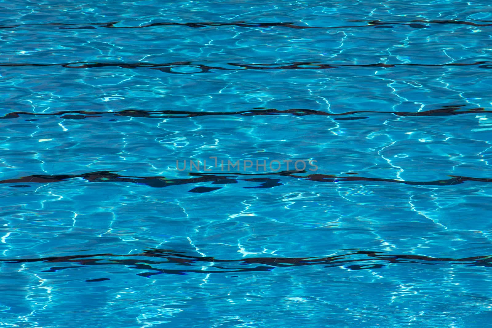 Blue pool water with sun reflections