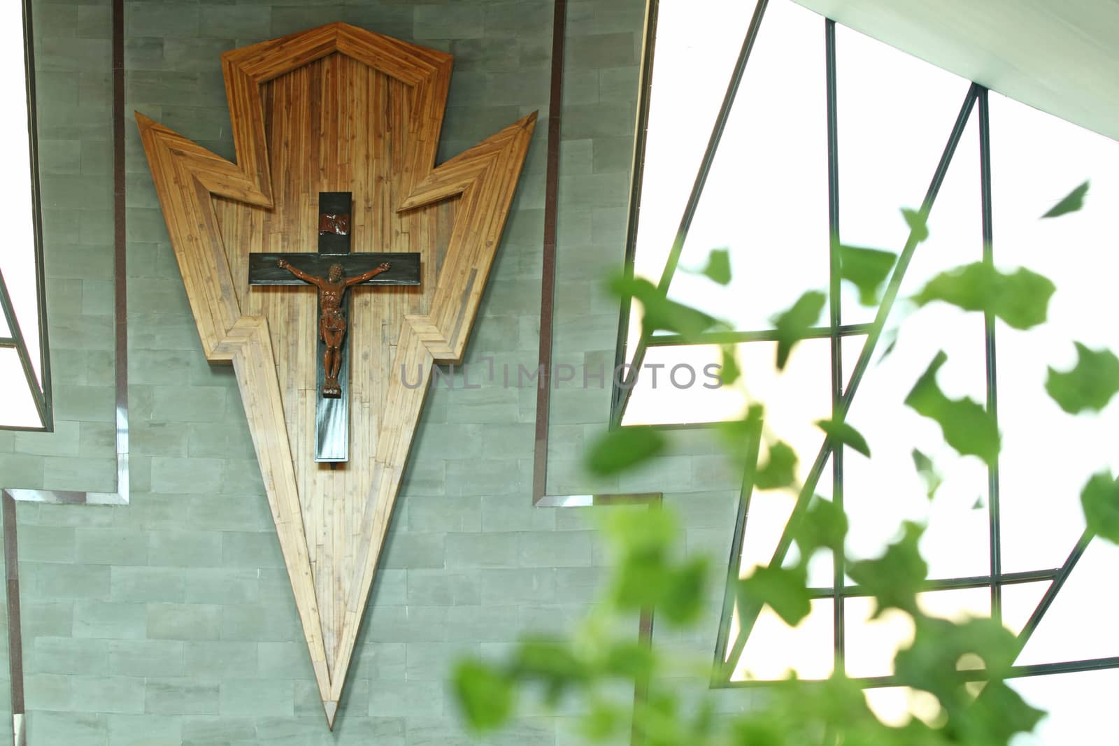 Cross on wooden wall background in church