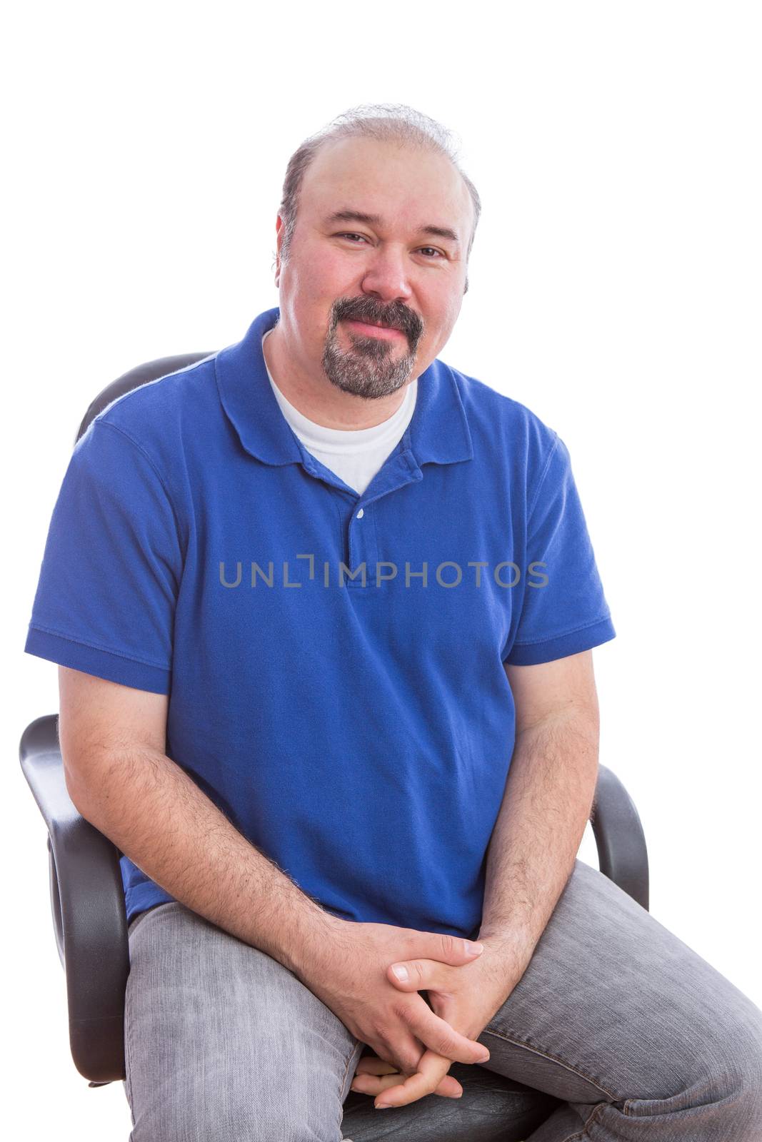 Close up Bearded Man in Blue Polo Shirt, Sitting on a Chair in an Optimistic Emotion and Looking at the Camera. Isolated on White Background.