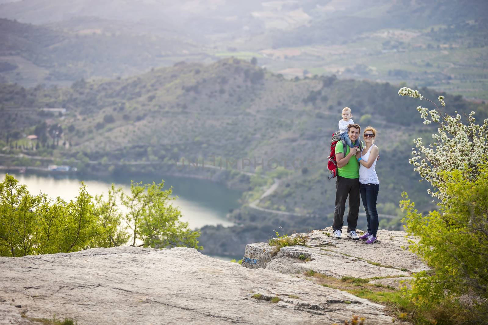 Young couple with toddler boy standing on cliff by photobac