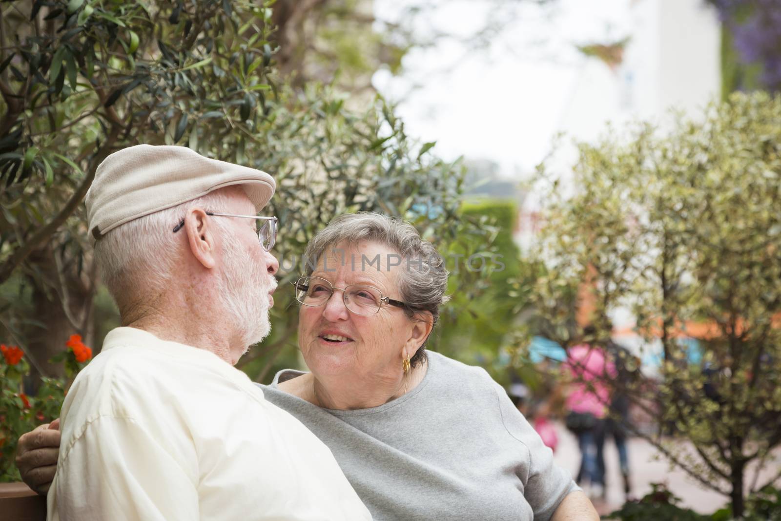 Happy Senior Couple Resting on a Bench in the Market Place.