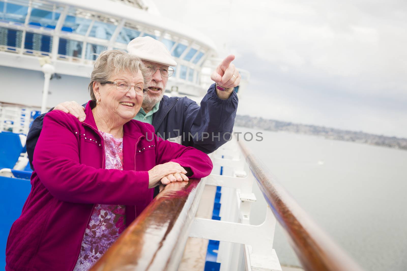 Happy Senior Couple Enjoying The View From Deck of a Luxury Passenger Cruise Ship.