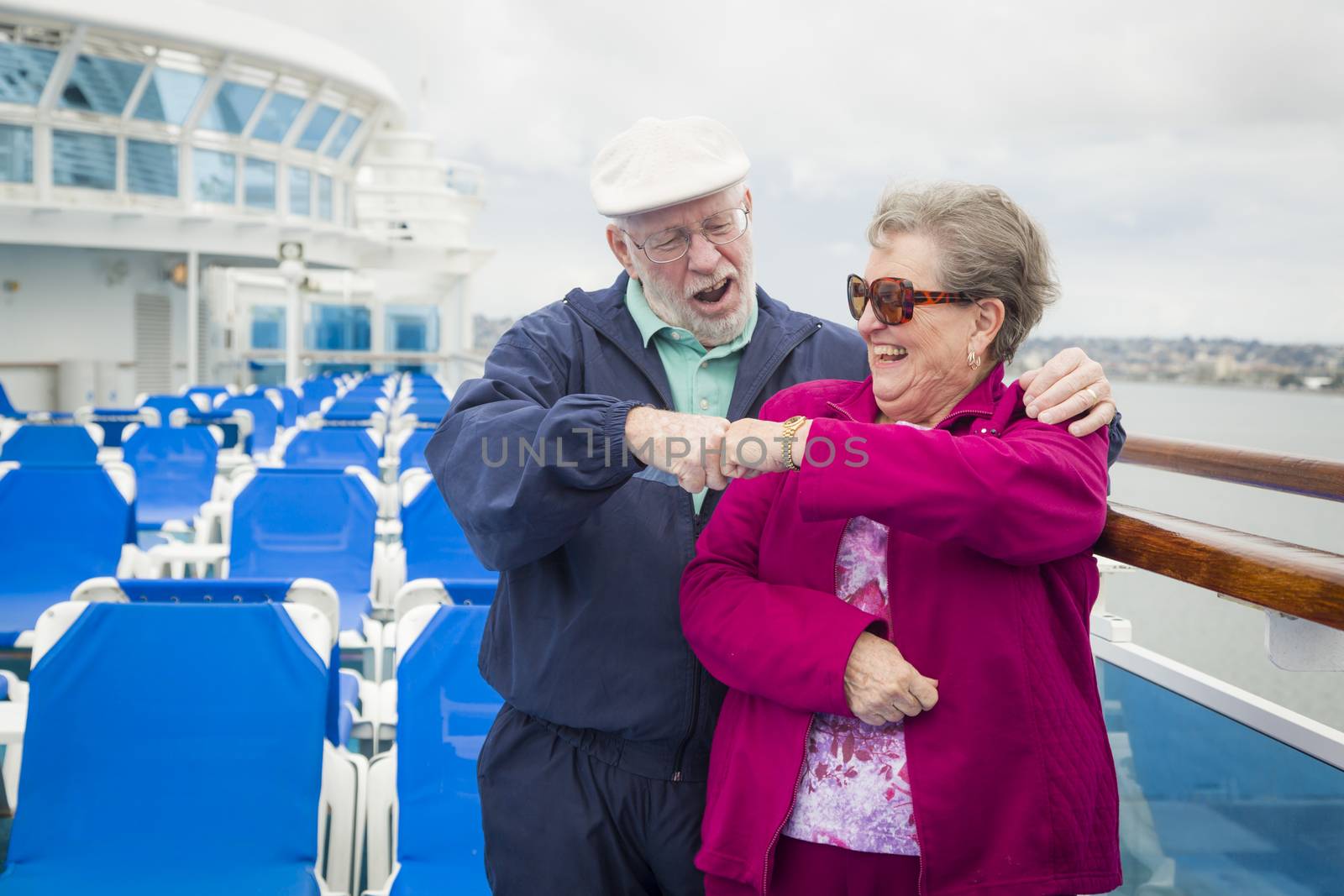 Senior Couple Fist Bump on Deck of Cruise Ship by Feverpitched