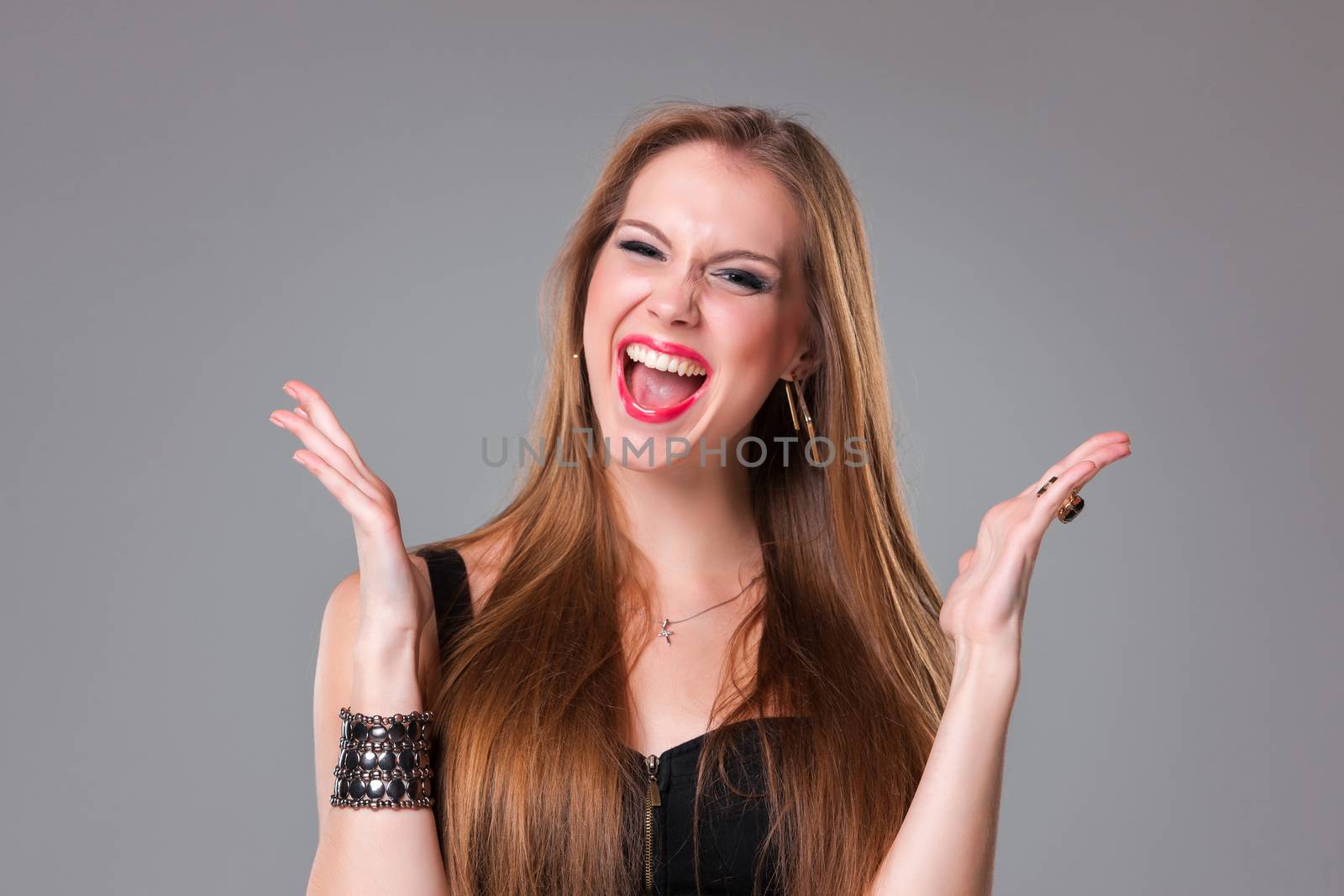 Portrait of happy brunette looking at camera on a gray background