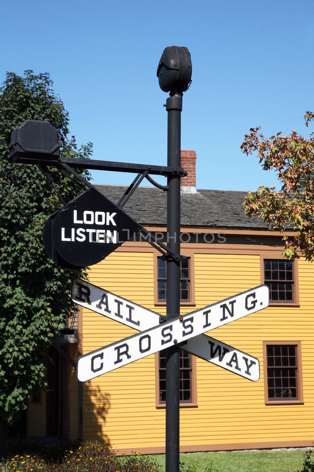 Vintage "Railroad Crossing" sign with building in background by jimmartin