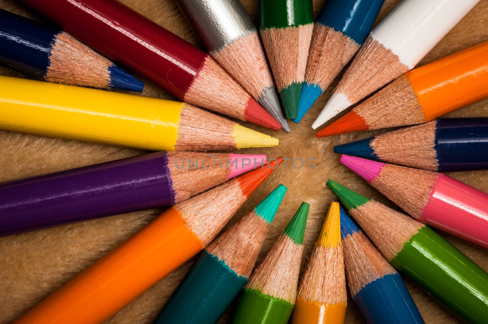 Colorful wooden pencils isolated on brown background