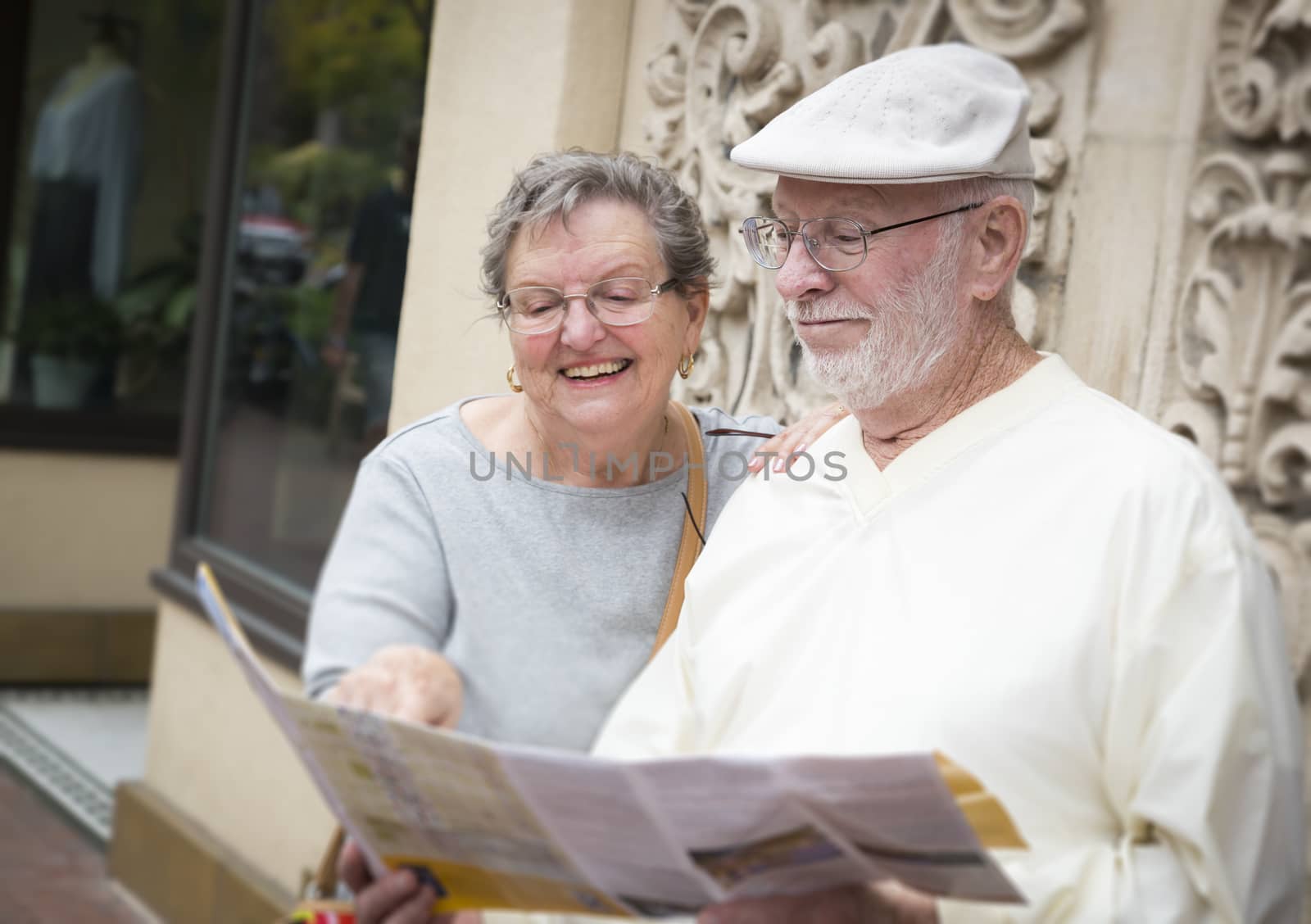 Tourist Senior Couple Looking at Brochure Map by Feverpitched