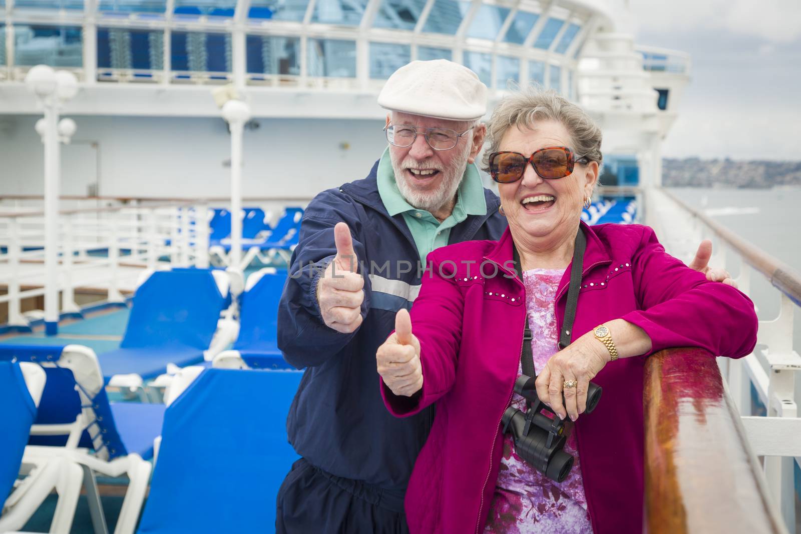 Happy Senior Couple With A Thumbs Up On The Deck of A Luxury Passenger Cruise Ship.