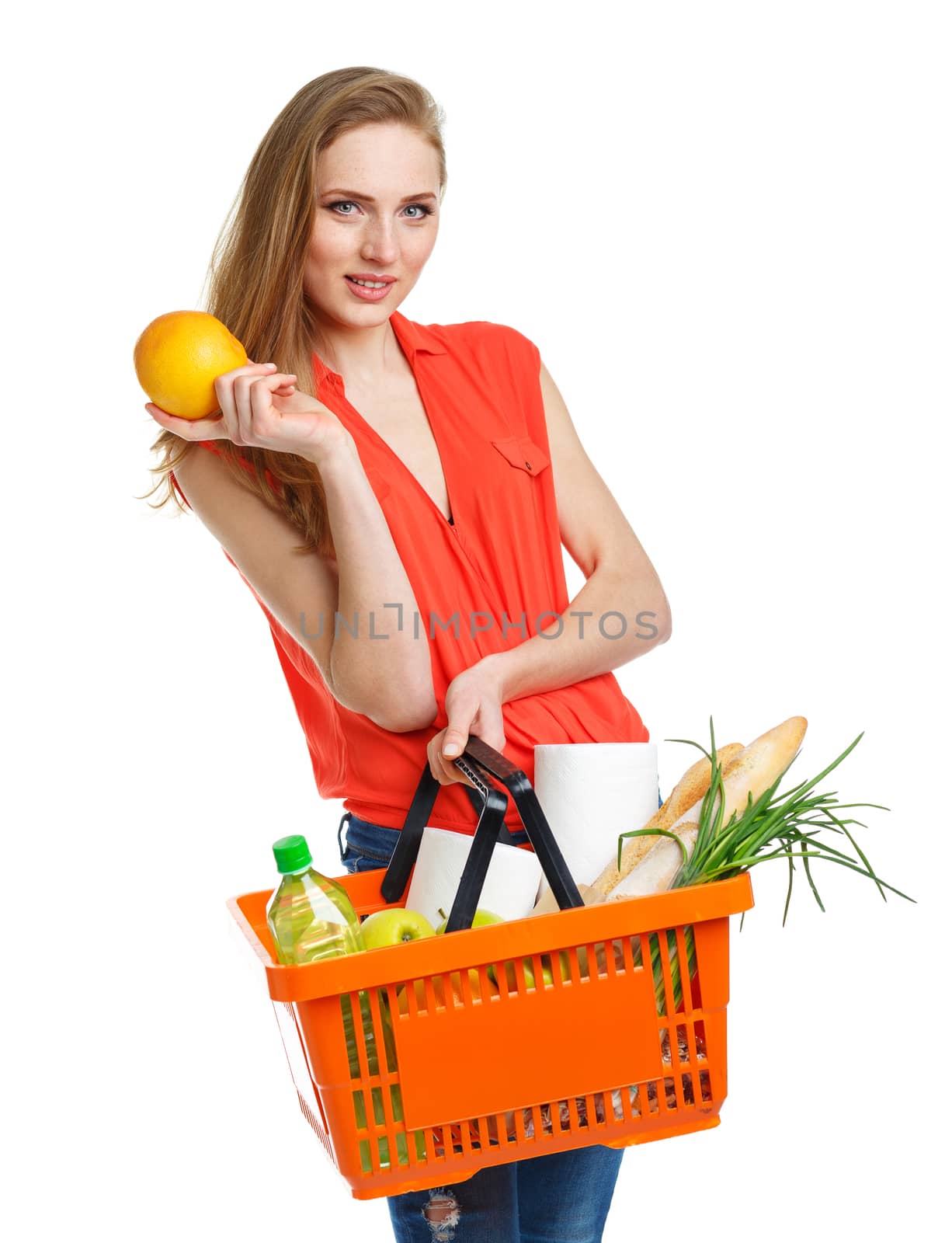 Happy young woman holding a basket full of healthy food. Shopping