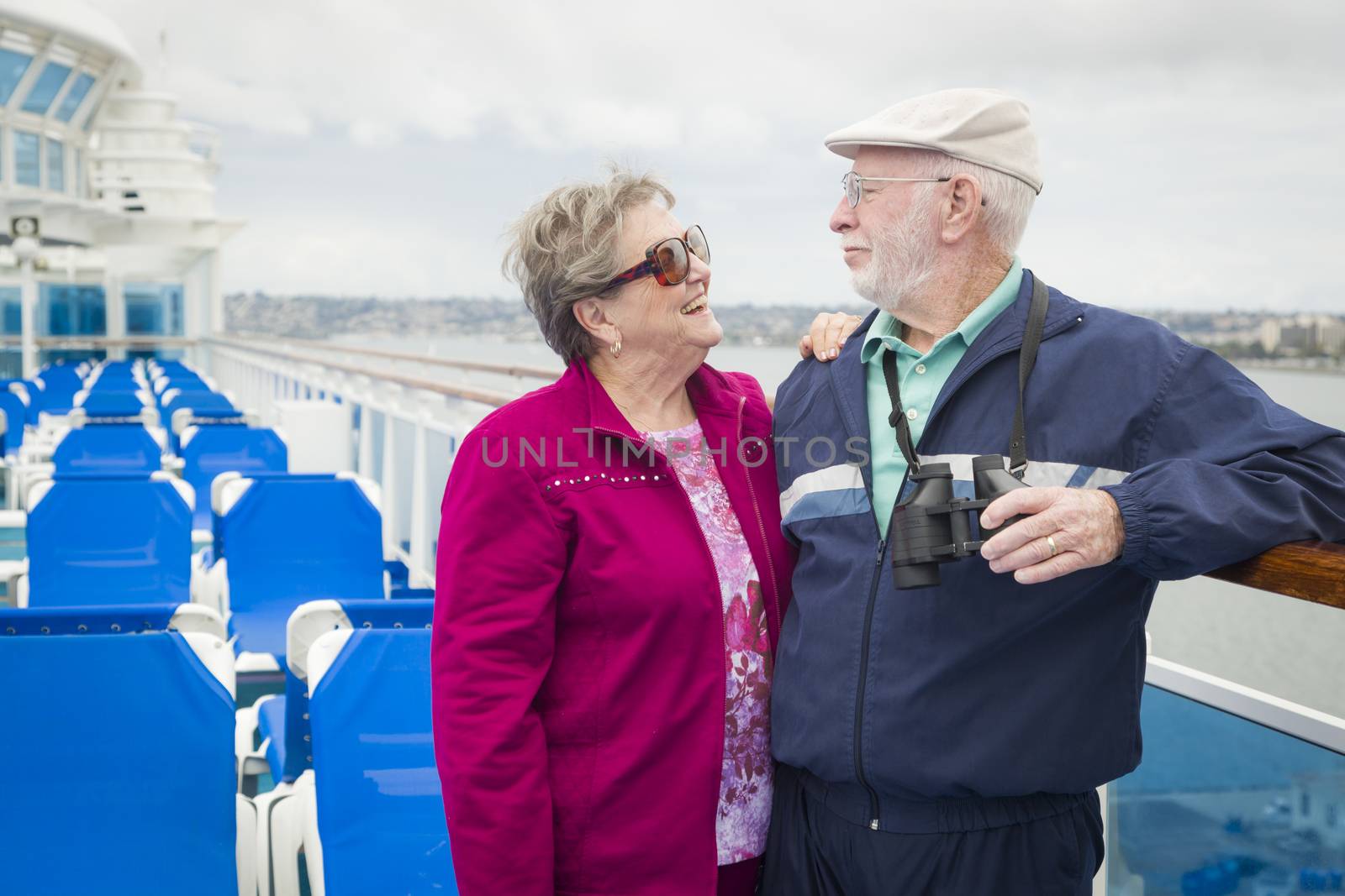 Happy Senior Couple Enjoying The View From Deck of a Luxury Passenger Cruise Ship.