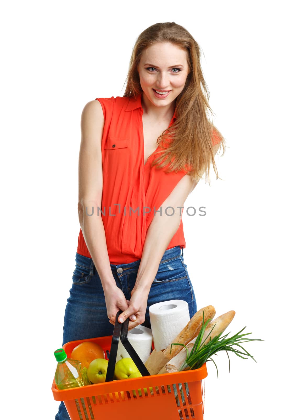 Happy young woman holding a basket full of healthy food. Shopping