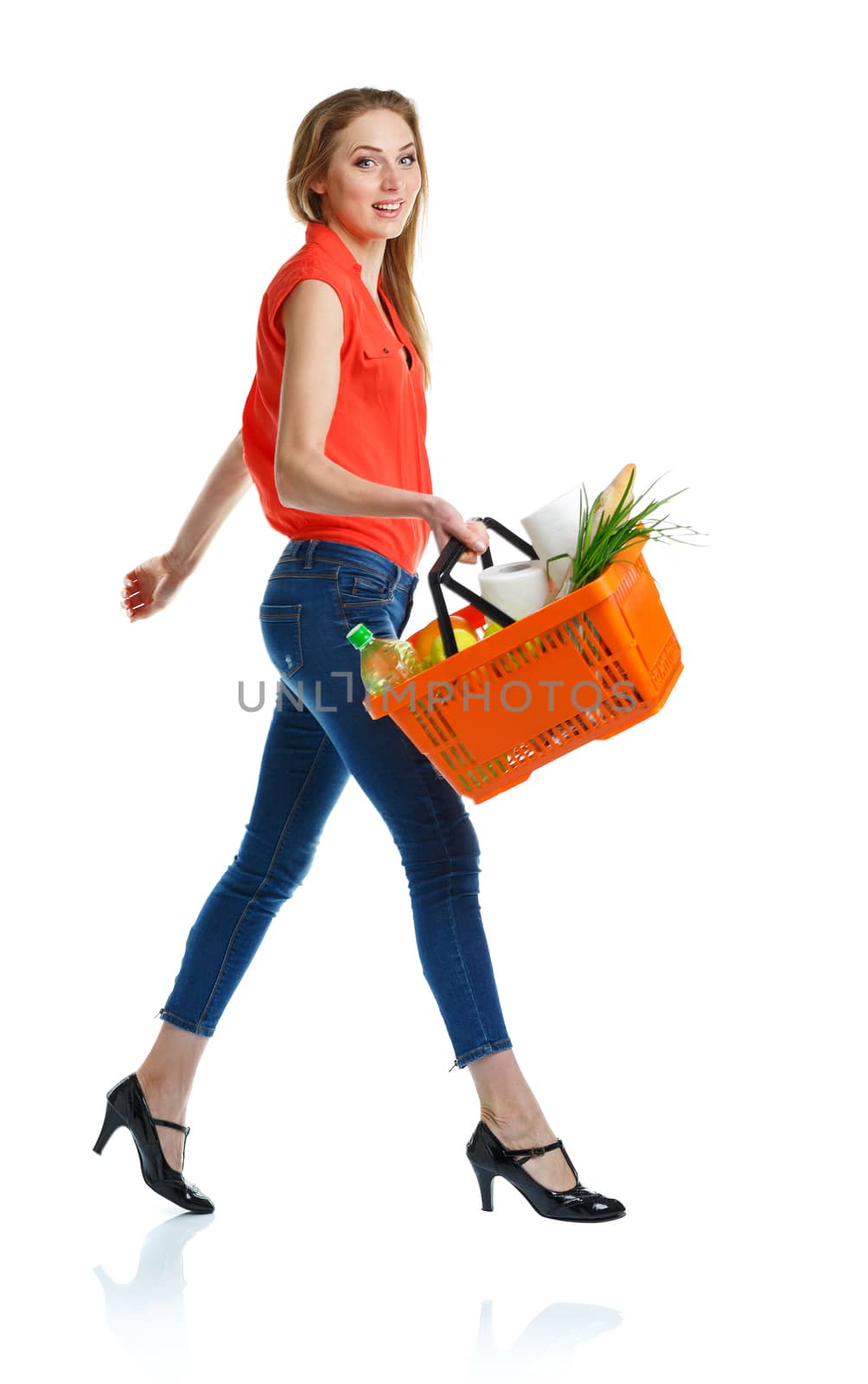 Happy young woman holding a basket full of healthy food. Shopping